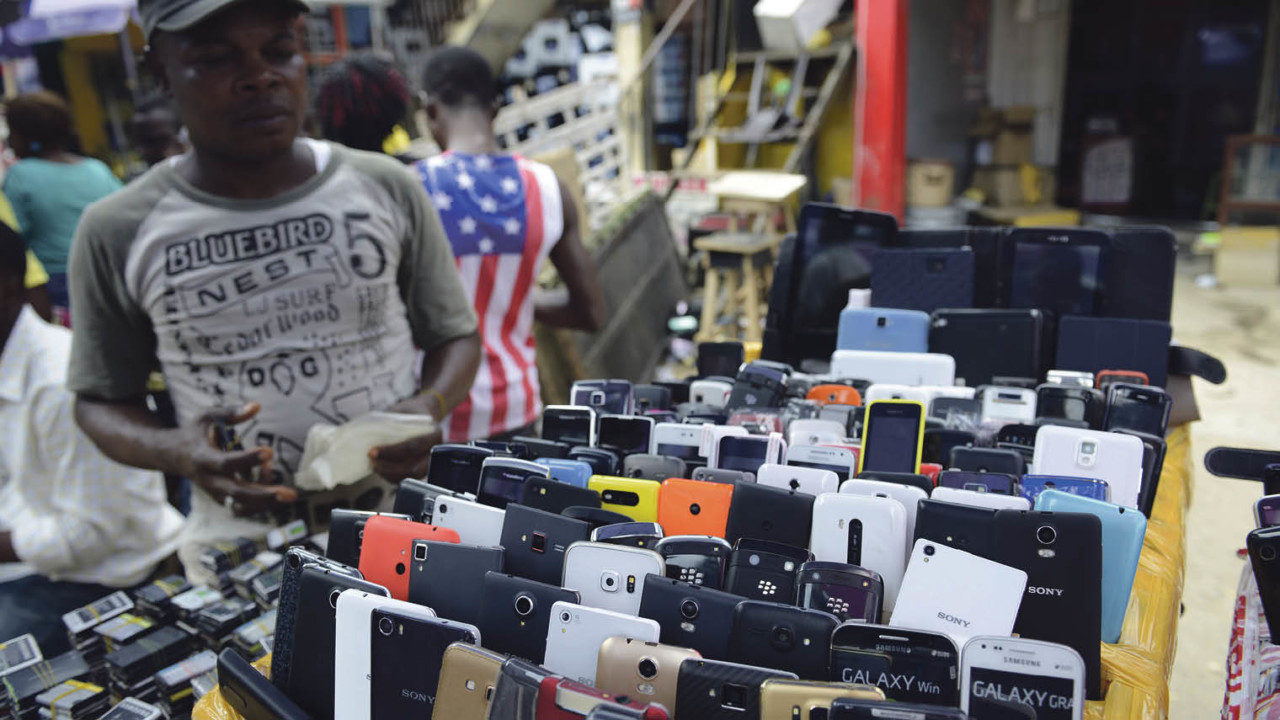 A phone vendor beside his stand at Computer Village, a consumer tech market in Lagos; the proliferation of smartphones in emerging markets such as Nigeria is generating massive amounts