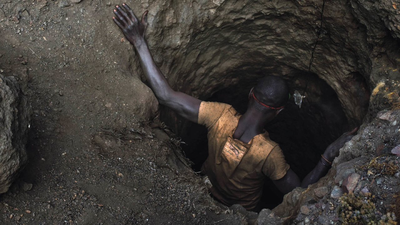 Mining employee, or creuseur, descends into a copper-cobalt mine in Kawama, Democratic Republic of the Congo, where conditions are dangerous with little to no safety equipment or structural support in the tunnels; they are paid on average $2 to $3 a day