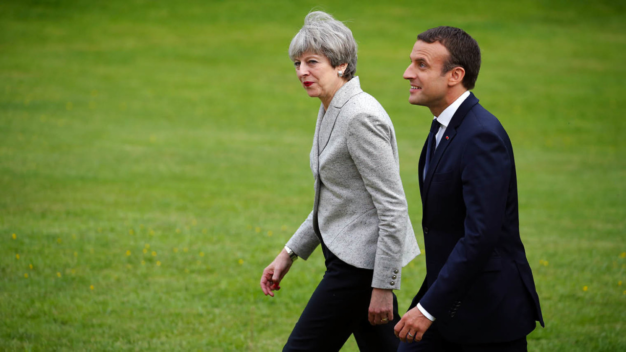 Theresa May and Emmanuel Macron walking