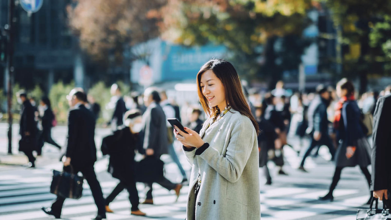 business woman on looking on phone in crowd of people travel chatbots