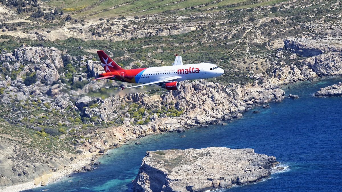 Air Malta plane flying over island and sea