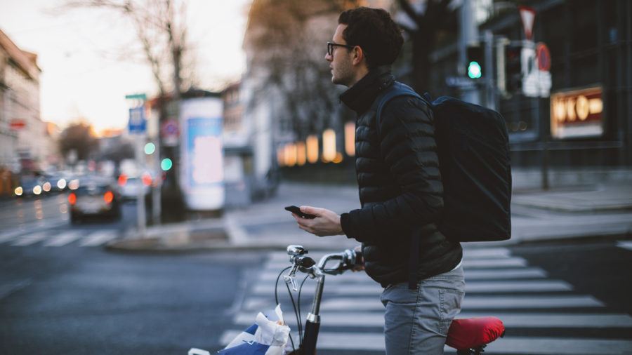 Man standing with bicycle holding phone