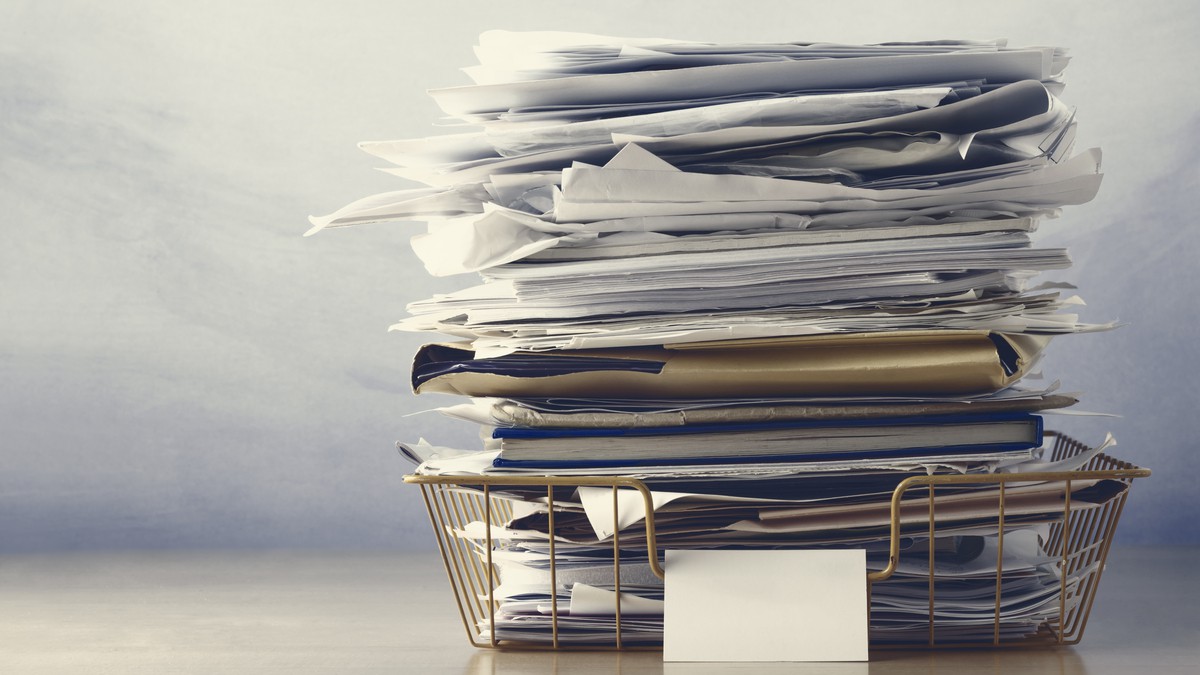 Stack of papers on desk representing workplace stress