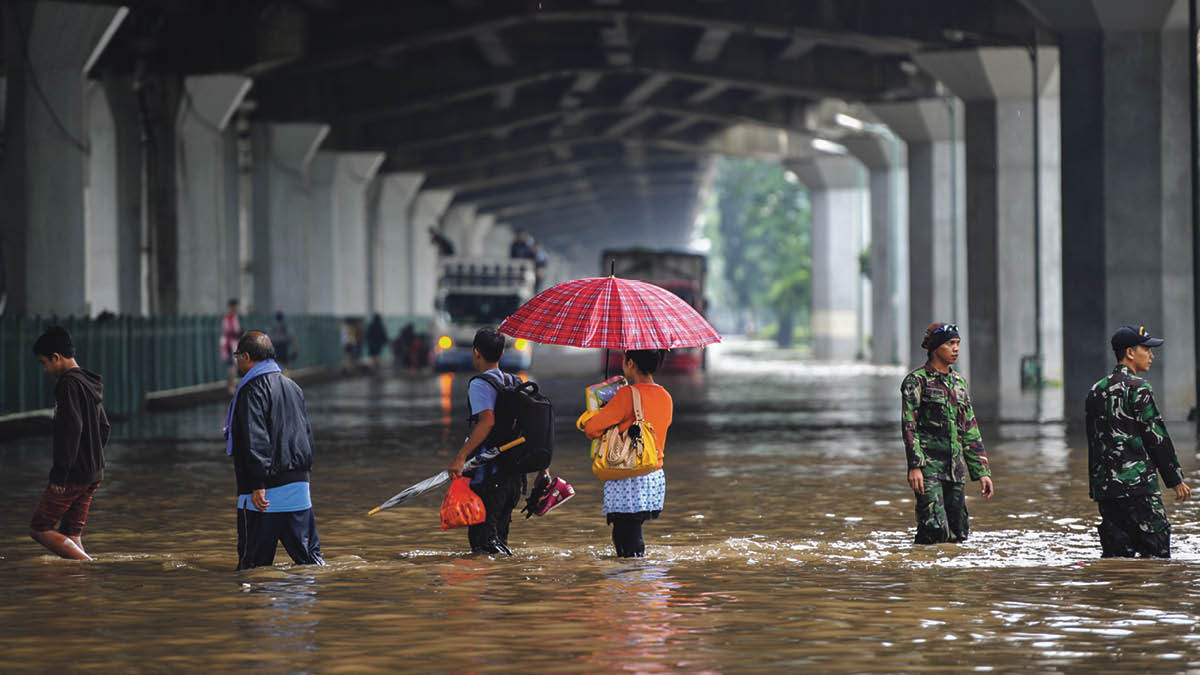 Residents on Jakarta’s Yos Sudarso Street wading through flood water in February 2015