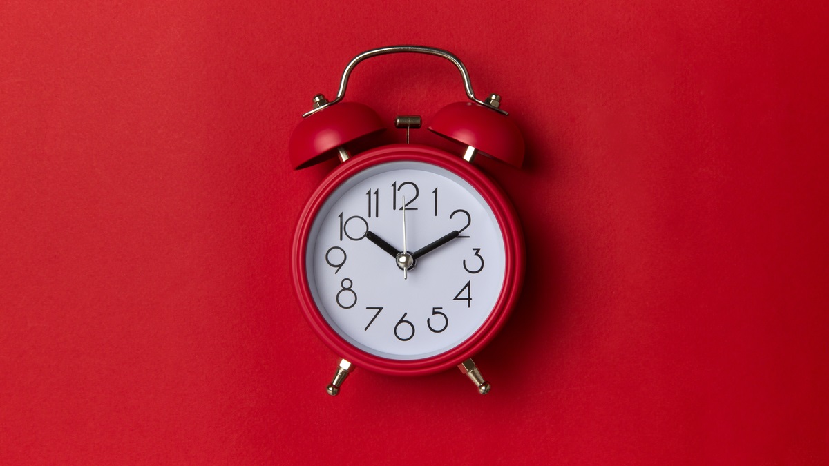 Red alarm clock on red background