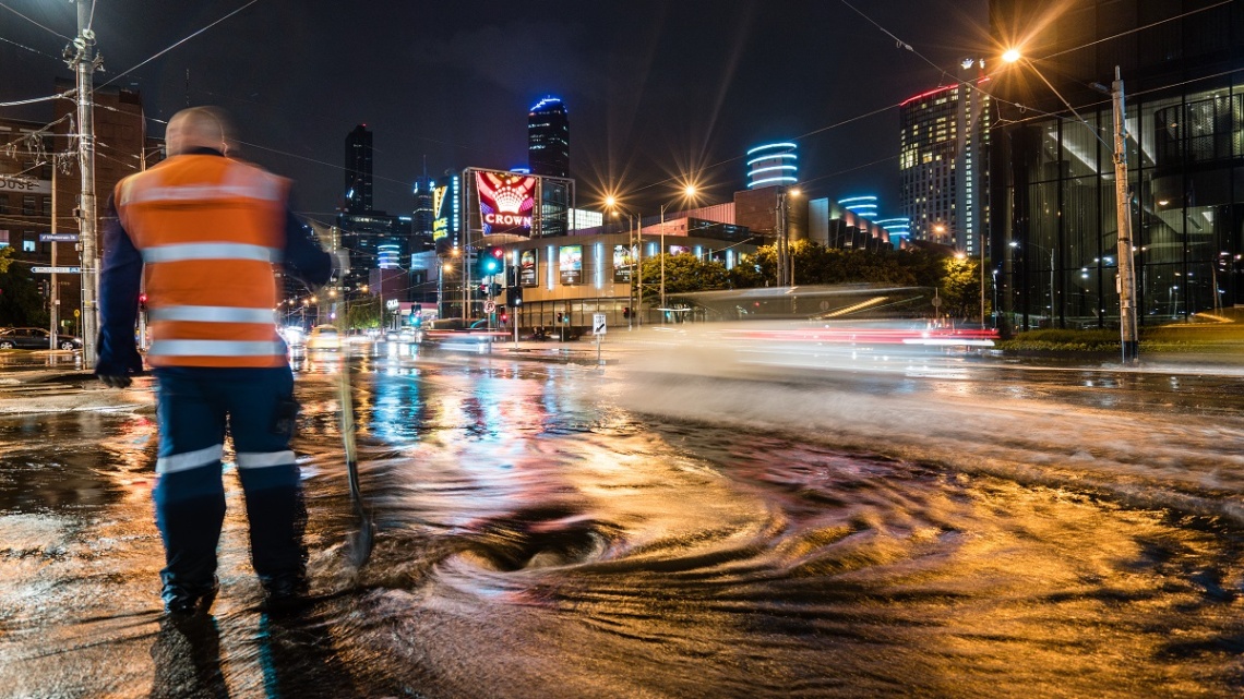 Man standing on flooded street at night
