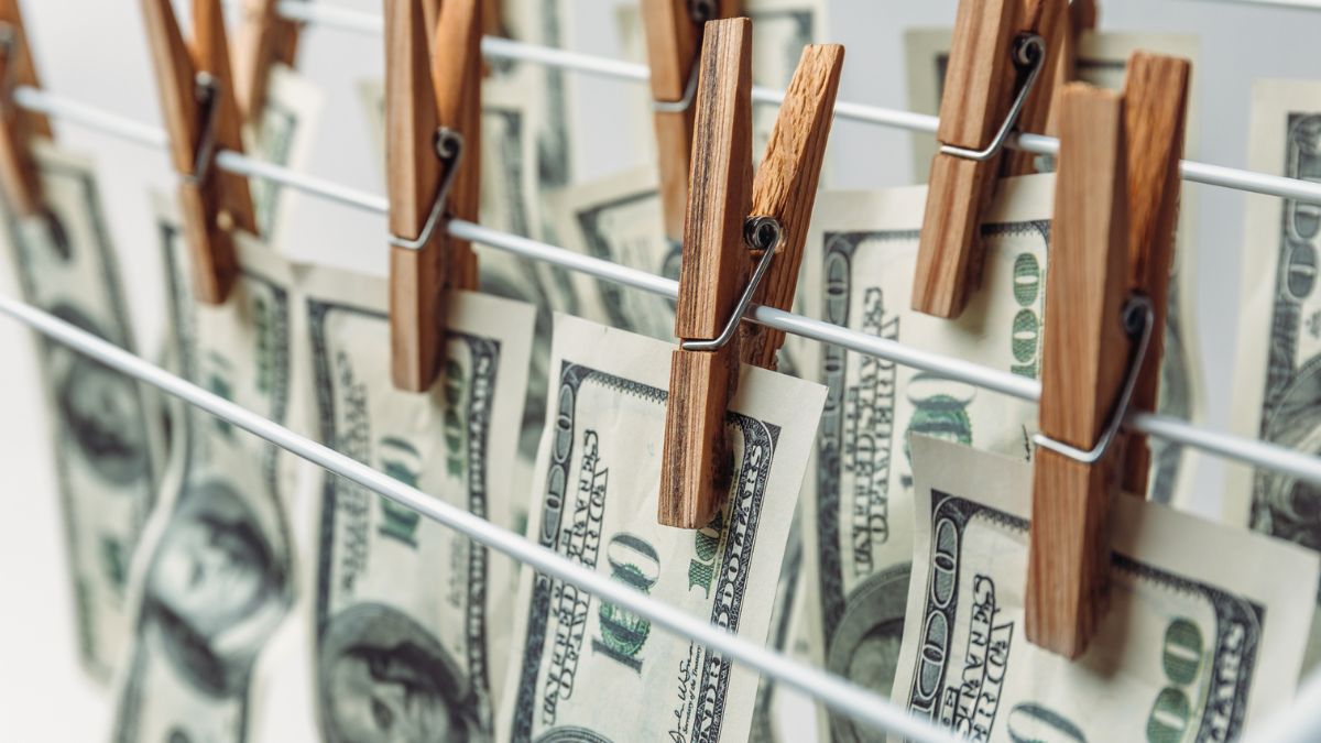 Image of 100-dollar bills hanging on a washing line. If companies don't stay compliant with new anti-money laundering regulations they may be left hung out to dry