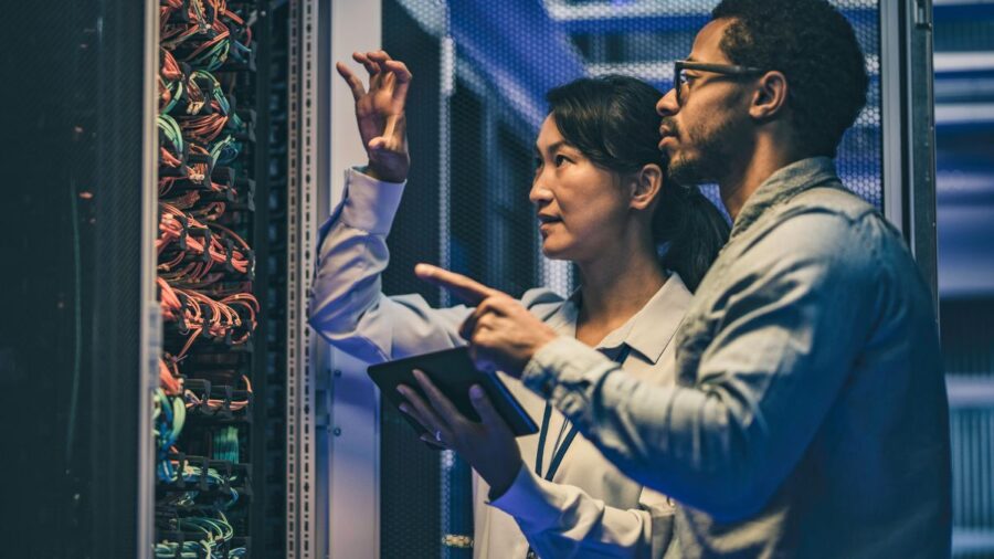 Female Asian It Technician Explaining Network Connection To A Novice Engineer Stock Photo