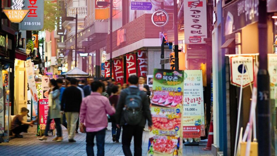 Seoul Myeongdong Shopping Street At Sunset With Sunlight Piercing Through The Advertising Signs