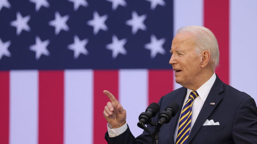 President Joe Biden speaking in front of a large American flag.