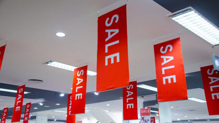 Sales signs hanging from the ceiling of a retail store