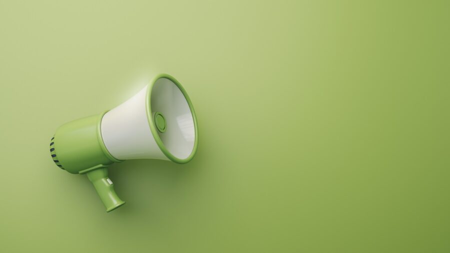 Green megaphone on green background to illustrate article about greenhushing